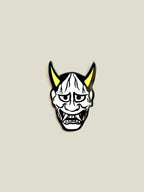 White Hannya enamel pin with yellow horns and black nickel finish.