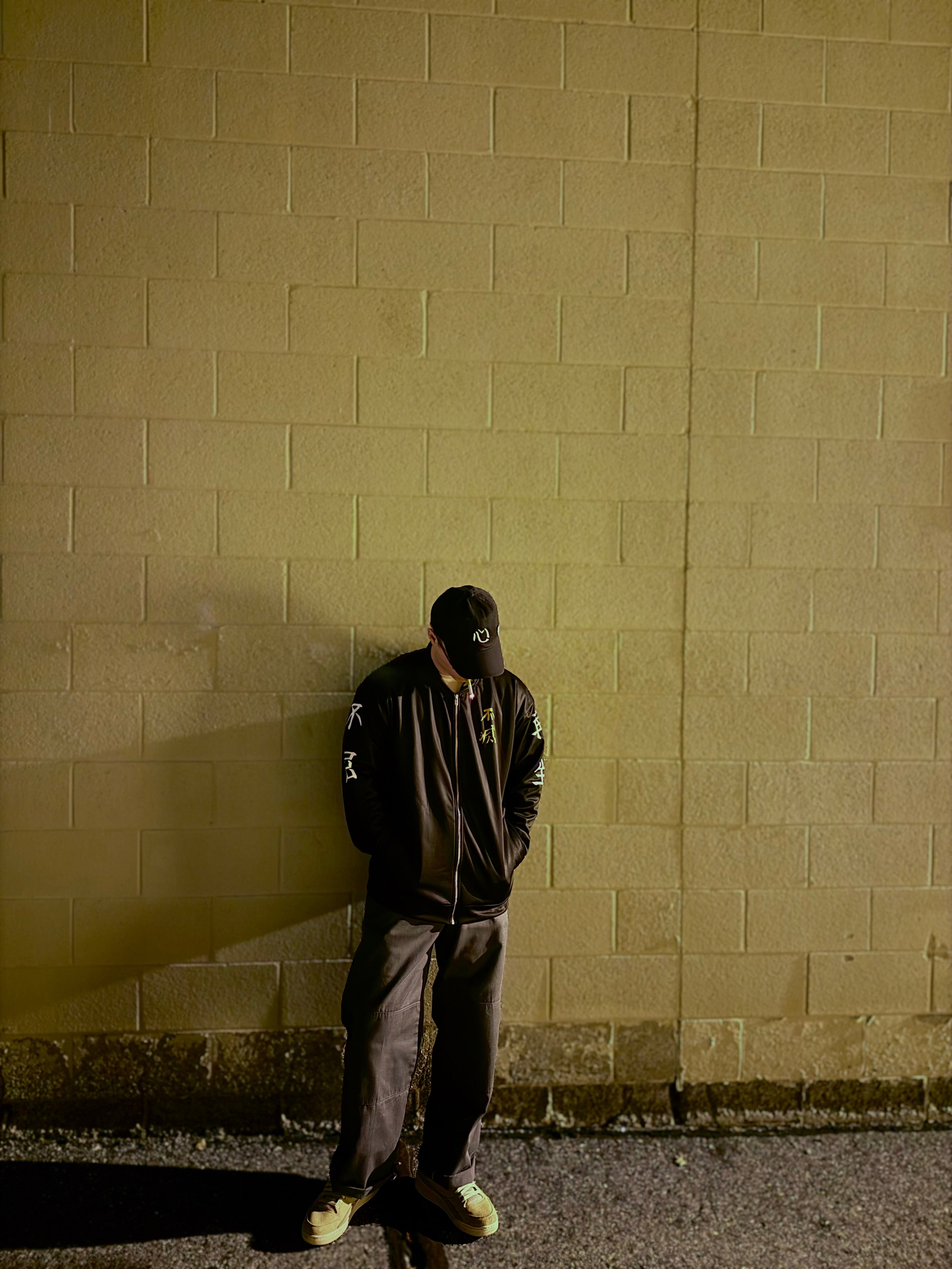 Person wearing black tokko fuku jacket standing against a wall
