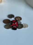 Tengu enamel pin displayed on Japanese yen coins