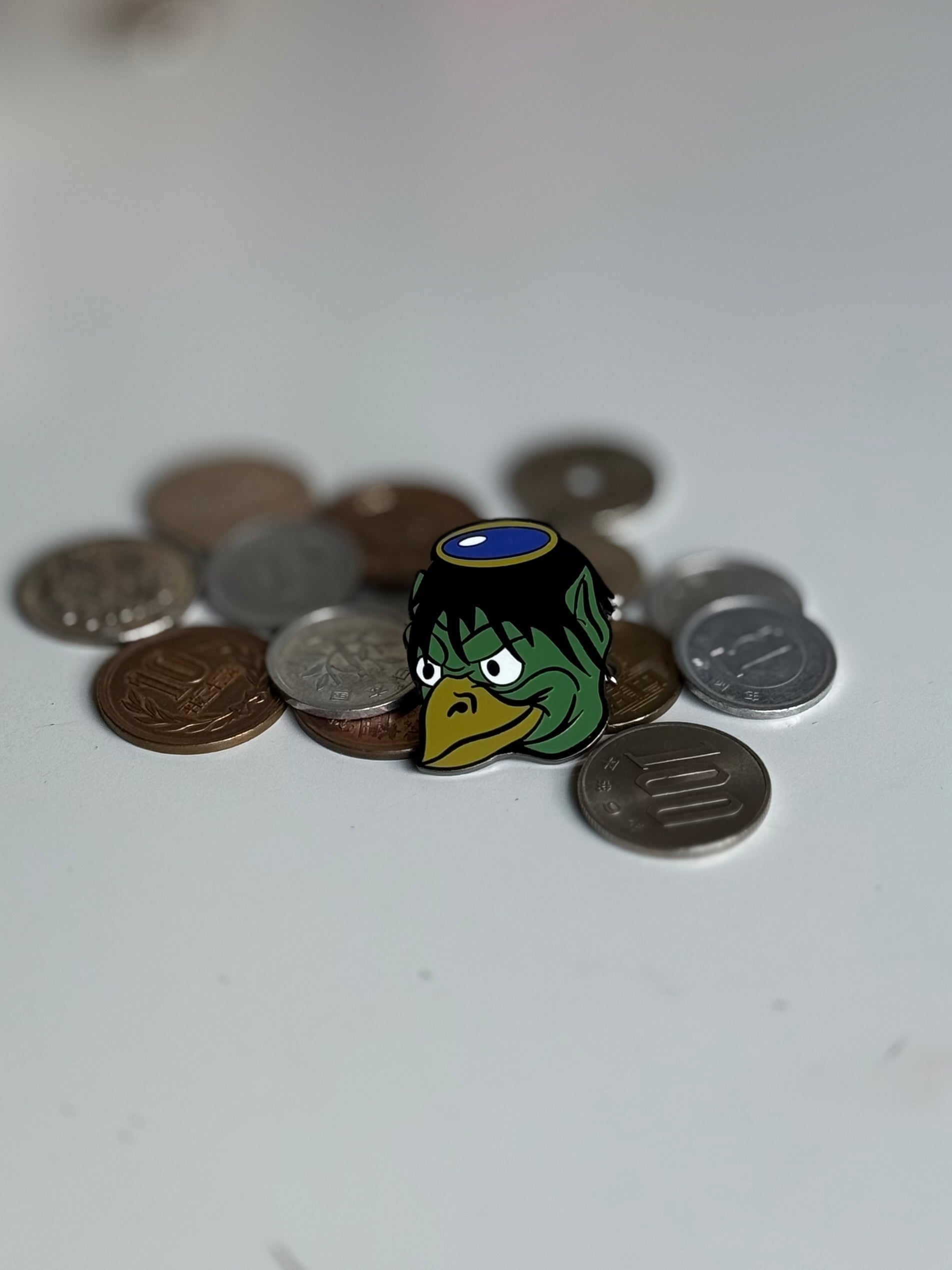 Japanese yokai, Kappa, enamel pin displayed on Japanese yen coins
