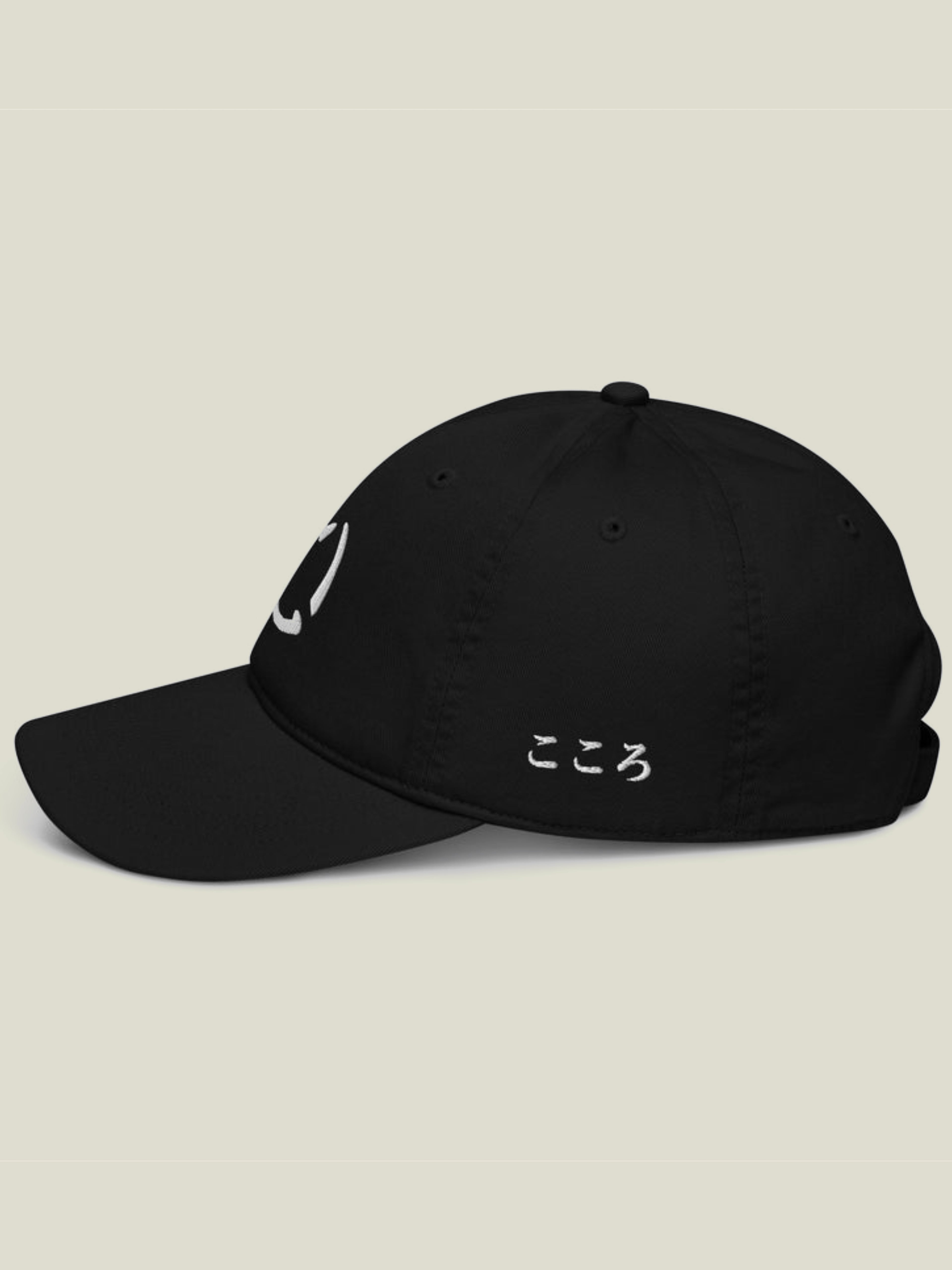 Black dad hat with white embroidery of Kokoro hiragana on the left side